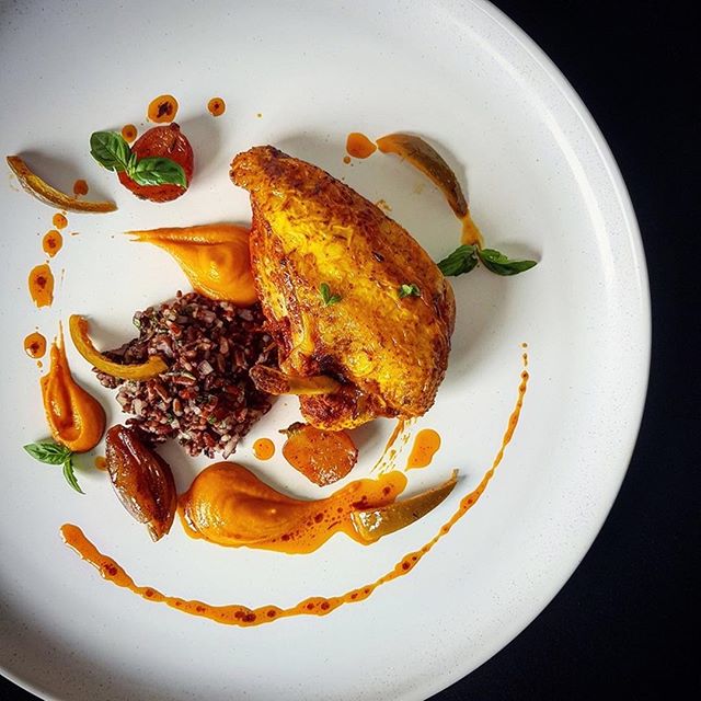 Chicken breast poached in curry stock with roasted yellow tomato puree, red rice pilaf, pickled lime and curry oil by Kareem Roberts, brokedinner⠀⠀